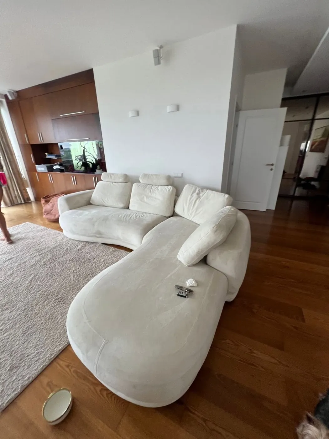 Svetainė su balta moduline sofa prie didelių langų