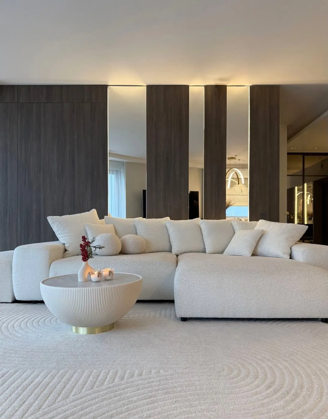 Šviesi svetainė su balta sofa ir apvaliu kavos staliuku